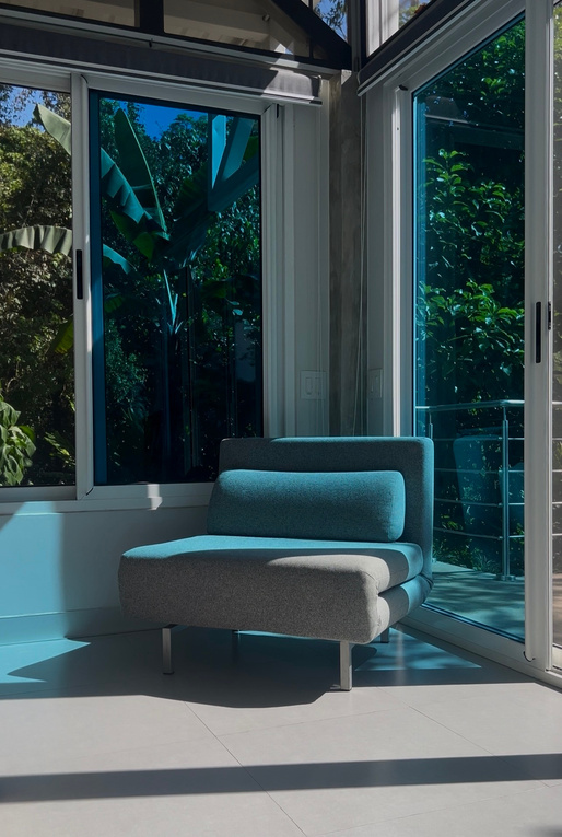 Lounge chair beside floor-to-ceiling windows